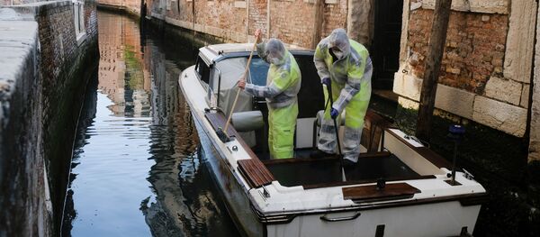 Dipendenti municipali in costumi protettivi disinfettano una barca a Venezia, Italia Dipendenti municipali in costumi protettivi disinfettano una barca a Venezia, Italia - Sputnik Afrique