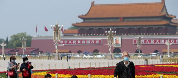 People wearing face masks following the coronavirus disease (COVID-19) outbreak walk past flower installations set up to mark the upcoming Labour Day holiday, at Tiananmen Square in Beijing, China April 29, 2020 - Sputnik Afrique