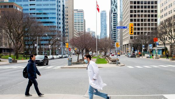 A health care worker runs across University Avenue from Mount Sinai Hospital to Toronto General Hospital as the number of the coronavirus disease (COVID-19) cases continues to grow in Toronto, Ontario, Canada April 17, 2020.  - Sputnik Afrique