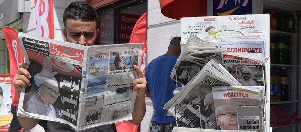 Un homme lit un journal devant un kiosque (Tunisie) - Sputnik Afrique