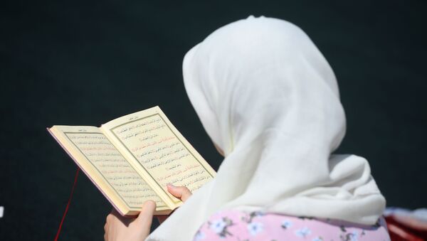 Une femme lisant le Coran  - Sputnik Afrique