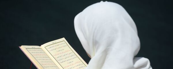 Une femme lisant le Coran  - Sputnik Afrique