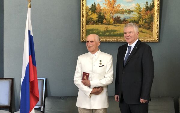 Jean Tcheriatchoukine a reçu le passeport russe des mains d'Alexeï Mechkov, l'Ambassadeur de la Russie, ce 29 mai 2020 - Sputnik Afrique