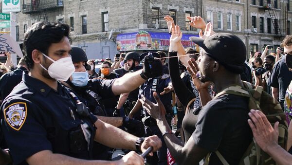A NYPD police officer sprays protesters as they clash during a march against the death in Minneapolis police custody of George Floyd, in the Brooklyn borough of New York City, U.S., May 30, 2020. - Sputnik Afrique