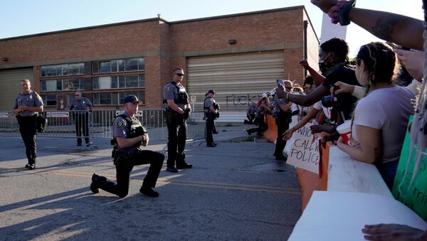Un policier a mis un genou à terre devant des participants aux rassemblements aux États-Unis, le 31 mai 2020 - Sputnik Afrique