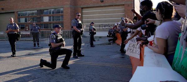 Un policier a mis un genou à terre devant des participants aux rassemblements aux États-Unis, le 31 mai 2020 - Sputnik Afrique