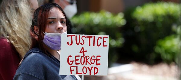 Une protestataire devant la maison de Derek Chauvin - Sputnik Afrique