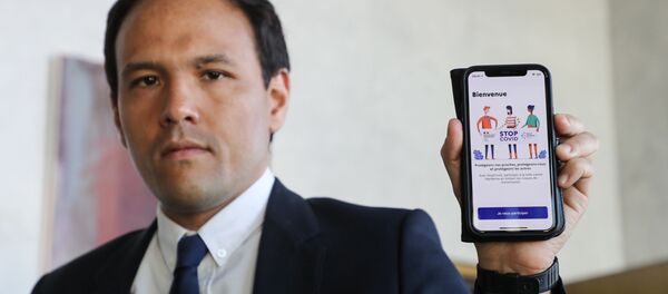 Le secrétaire d'Etat au numérique Cédric O  tient en main un smartphone montrant l'application StopCovid - Sputnik Afrique
