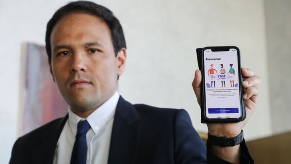 Le secrétaire d'Etat au numérique Cédric O  tient en main un smartphone montrant l'application StopCovid - Sputnik Afrique