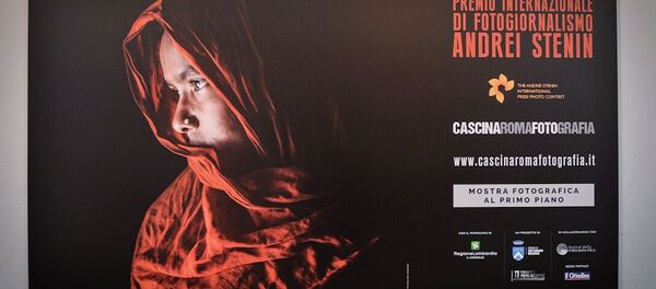 Une affiche de l'exposition des travaux des lauréats du Concours international de photojournalisme Andreï Stenine à la Cascina Roma Art Gallery à San Donato Milanese - Sputnik Afrique