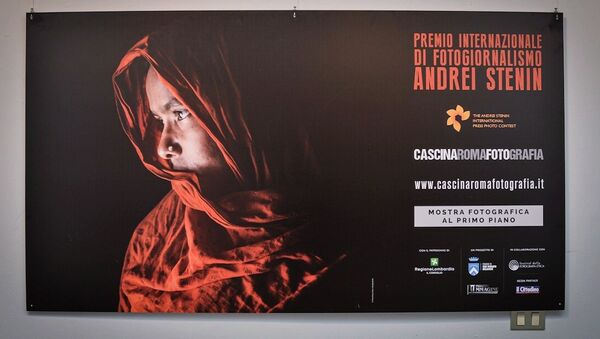 Une affiche de l'exposition des travaux des lauréats du Concours international de photojournalisme Andreï Stenine à la Cascina Roma Art Gallery à San Donato Milanese - Sputnik Afrique