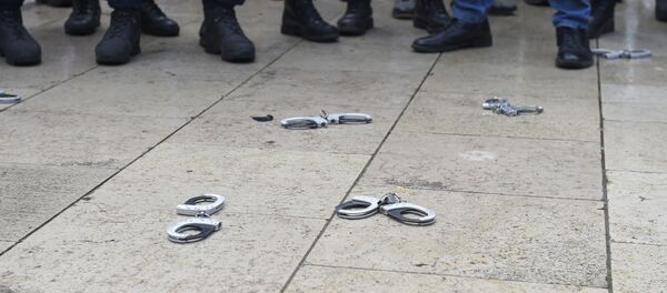 Des policiers français déposent symboliquement leurs menottes pour montrer leur colère. (Photo by NICOLAS TUCAT / AFP) - Sputnik Afrique