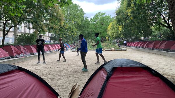 Des jeunes migrants jouent au football dans un parc parisien transformé en camp d'accueil  - Sputnik Afrique