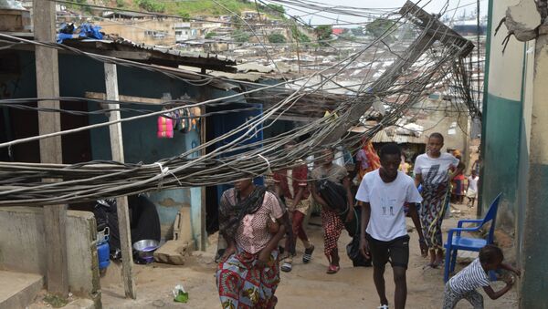 Des passants sous des fils électriques tombés d'un toit. - Sputnik Afrique