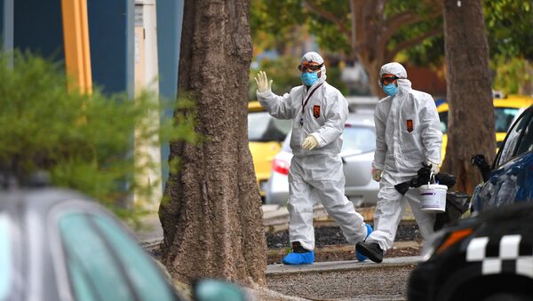 People in hazardous material overalls are seen outside of a public housing tower along Racecourse Road that was placed under lockdown due to the coronavirus disease (COVID-19) outbreak in Melbourne, Australia, July 6, 2020. - Sputnik Afrique