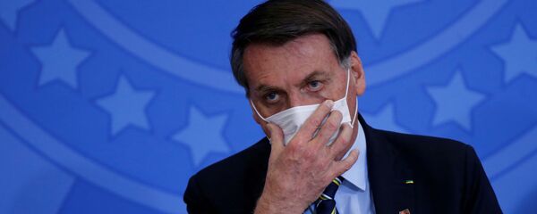 Le President Jair Bolsonaro ajuste un masque durant l'épidémie - Sputnik Afrique