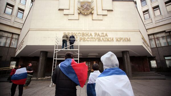 Des ouvriers enlèvent un panneau en ukrainien au siège du parlement criméen - Sputnik Afrique