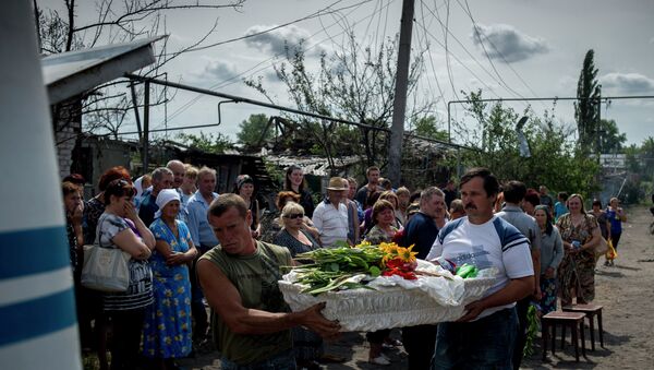 Les habitants du village de Louganskaïa (l'est de l'Ukraine) assistent à l'enterrement de leurs voisins tués dans un bombardement - Sputnik Afrique