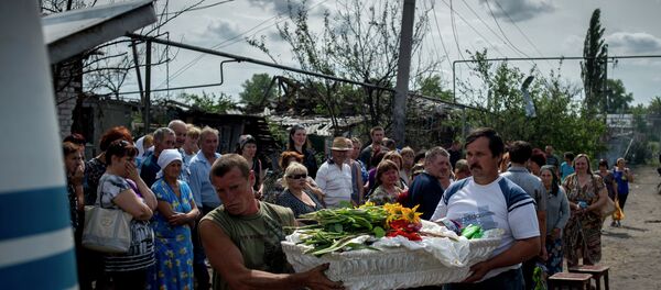 Les habitants du village de Louganskaïa (l'est de l'Ukraine) assistent à l'enterrement de leurs voisins tués dans un bombardement - Sputnik Afrique