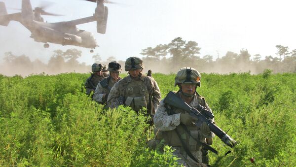 U.S. Marine Corps Pfc. Tony J. Desselle leads Marines to a collection area as a MV-22 Osprey takes flight after transporting Marines during a raid course on Camp Lejeune, N.C., Aug. 19, 2009. - Sputnik Afrique