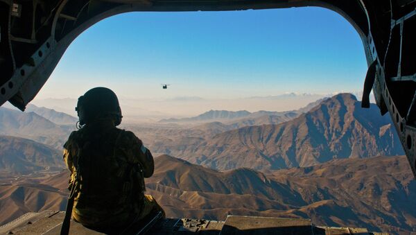 U.S. Army Spc. Devon Boxa, 7-158th Aviation Regiment, admires the Afghanistan landscape out the back door of her CH-47D Chinook helicopter as another Chinook follows - Sputnik Afrique